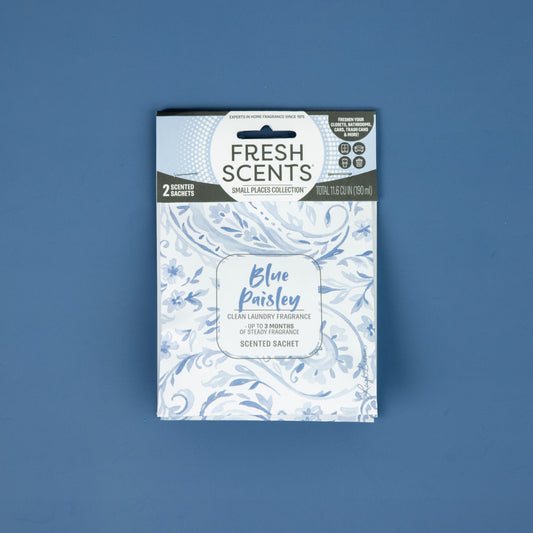 A 2-pack of Fresh Scents Paisley fragrance sachets, shown on a solid blue surface with light blue floral designs on a white package, works as a flameless air freshener for small spaces.