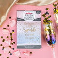 Load image into Gallery viewer, The Fresh Scents Little Sparkle - Sachet 3pk, featuring “She leaves a little sparkle wherever she goes,” rests on pink with rose petals, gold confetti, and a champagne flute—a flameless air freshener with long-lasting fragrance.
