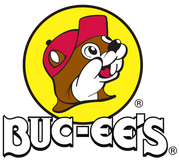 The Buc-ee’s logo featuring a cartoon beaver wearing a red cap, shown in profile, set inside a yellow circle above the bold, stylized text “BUC-EE’S.”.